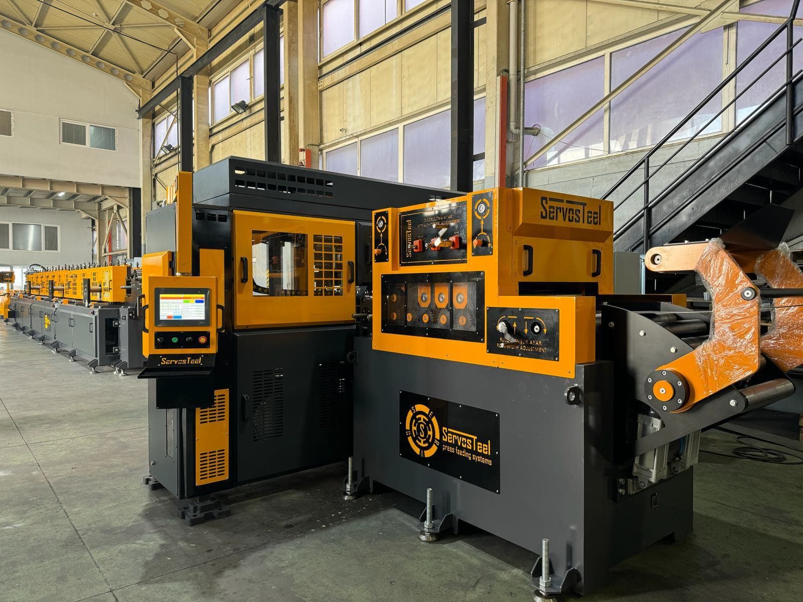 على الخط: فرّادة اللفائف ومغذّي السيرفو بالتقويم وServo Punch Press، وخلفها خط التشكيل بالدرفلة